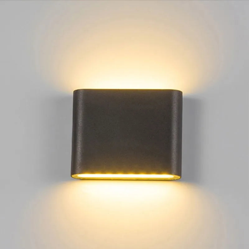 Black up/down wall light glowing on a wall