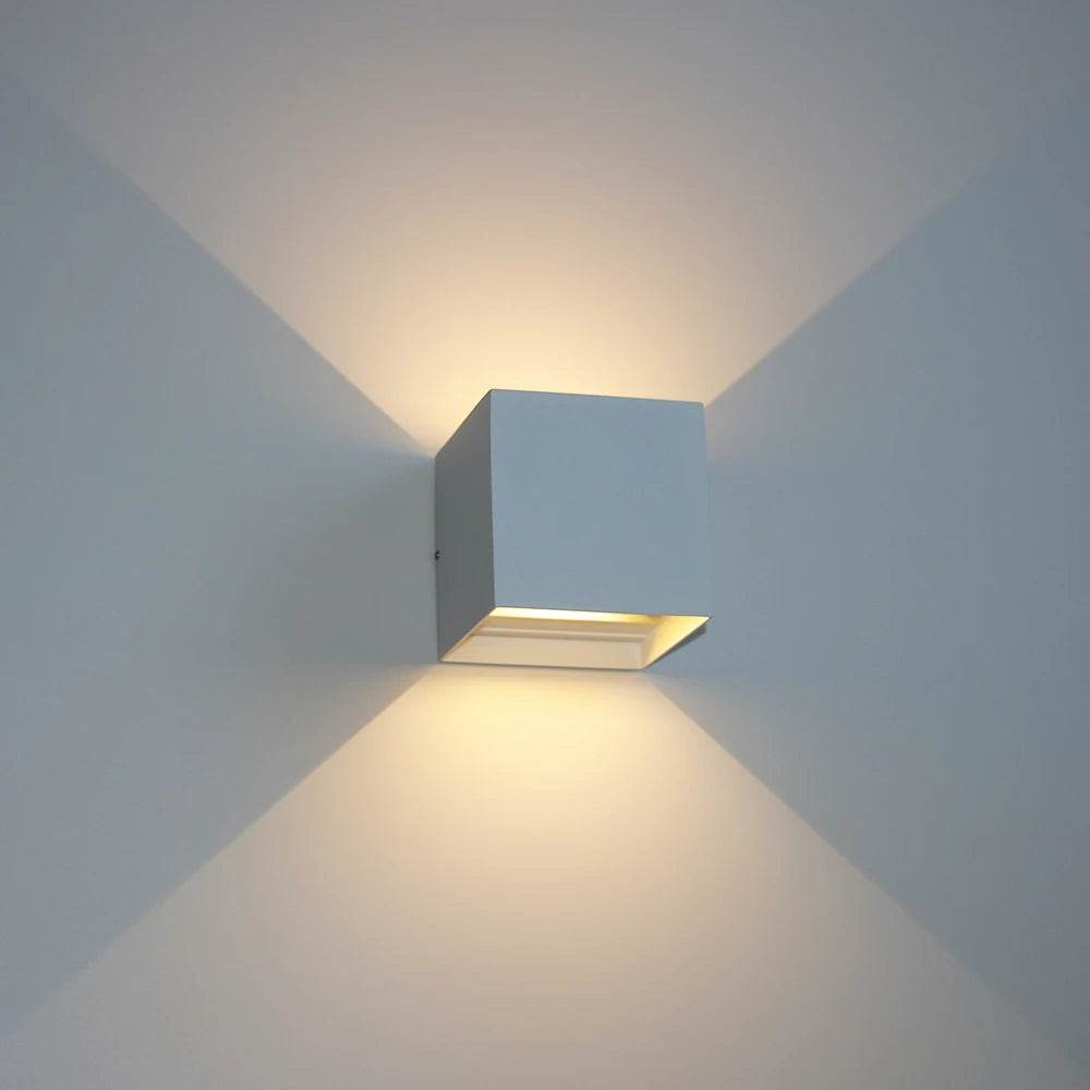 White cube wall light glowing on a wall