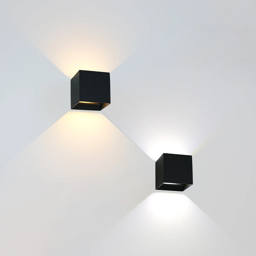 Two black cube wall lights casting beams