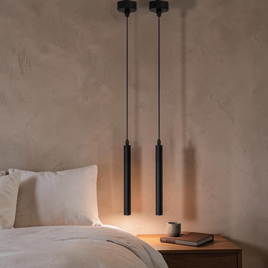 Pair of Tubo slim black cylinder pendant lights beside a bed in a modern bedroom